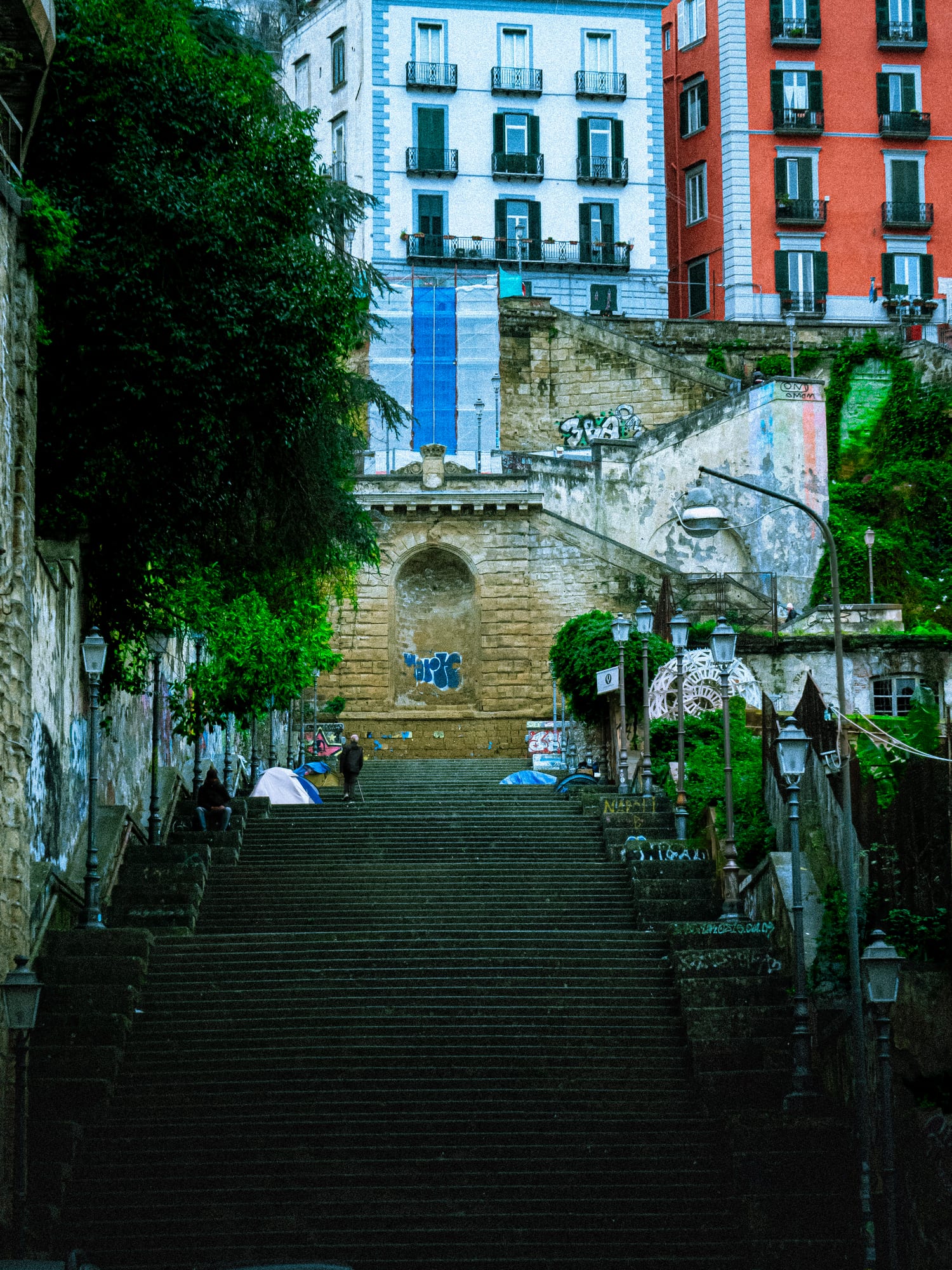 Long stone stairway running between blue, white and red painted Naples facades.
