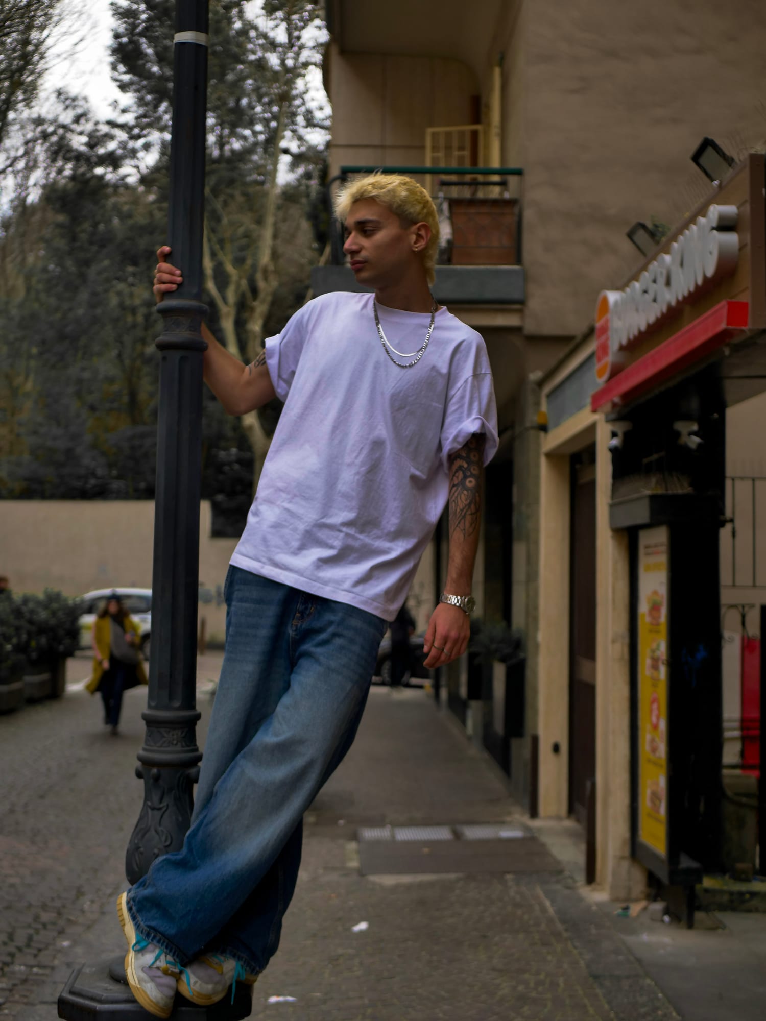 Salar leaning against a lamppost on a Naples street corner.